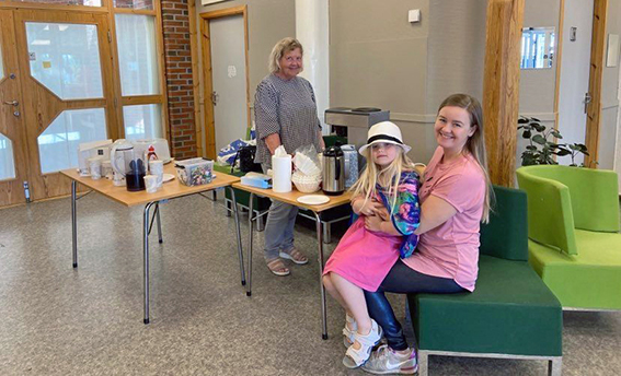 Invgill fra Seniorkafeen har sørget for kaffe og vaffler. Godt fornøyd klesbytter Anita (6) på fanget til mammaen sin.